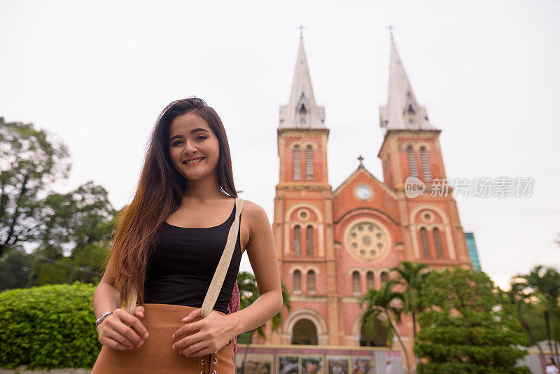 越南胡志明市，年轻美丽的亚洲女游客在西贡圣母院大教堂对面的肖像