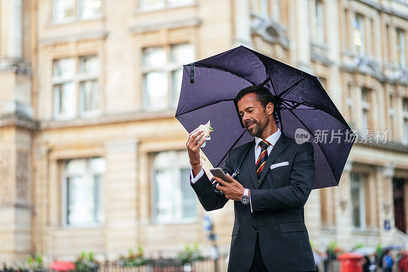 多任务商人在雨天的伦敦