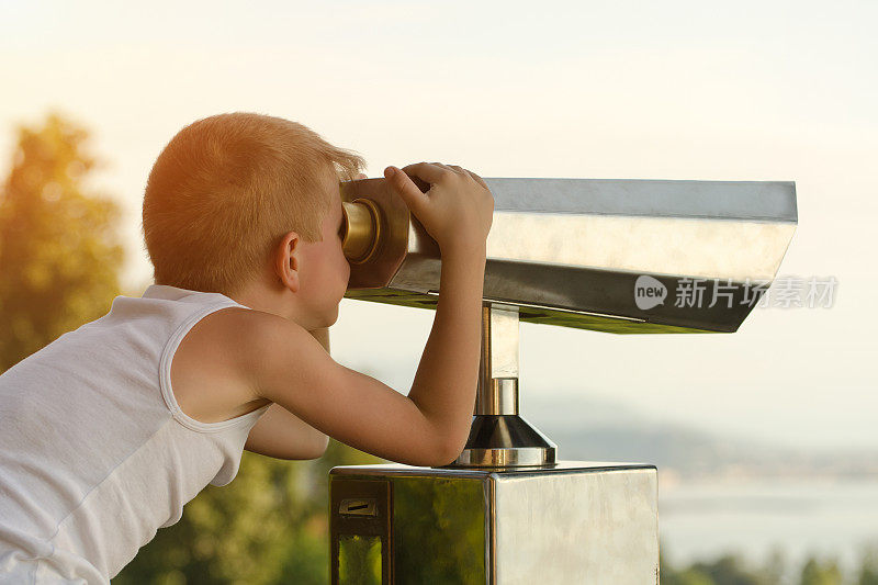 男孩看了看大望远镜。天空背景