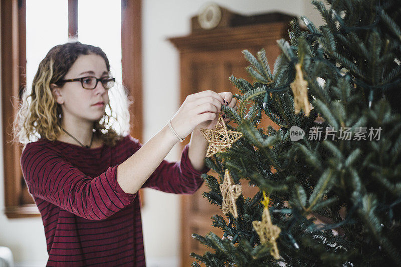 一位年轻女子在家里装饰圣诞树