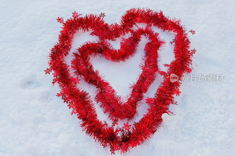 两颗红心在雪中用圣诞线做成