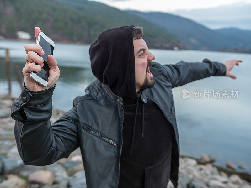 一个愤怒的男人把他的智能手机扔进了湖水里