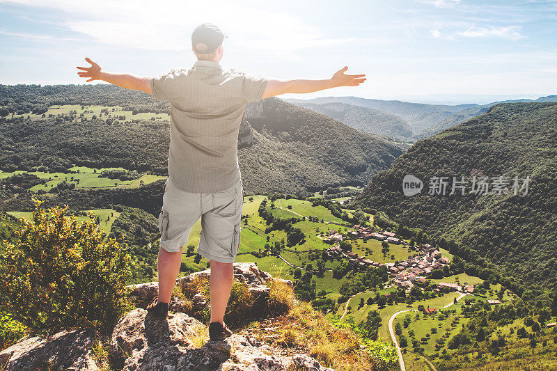 在艾因，年轻的男子在法国徒步旅行后举起手臂欣赏风景