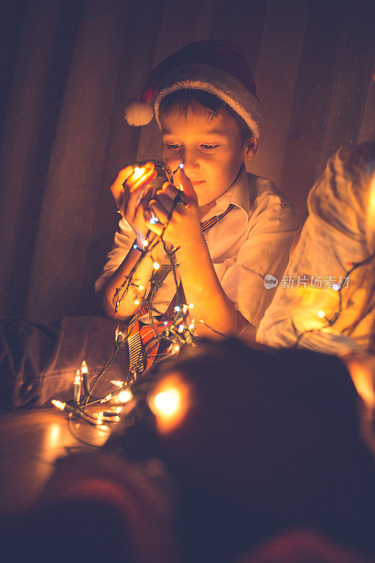 男孩拿着五颜六色的圣诞彩灯