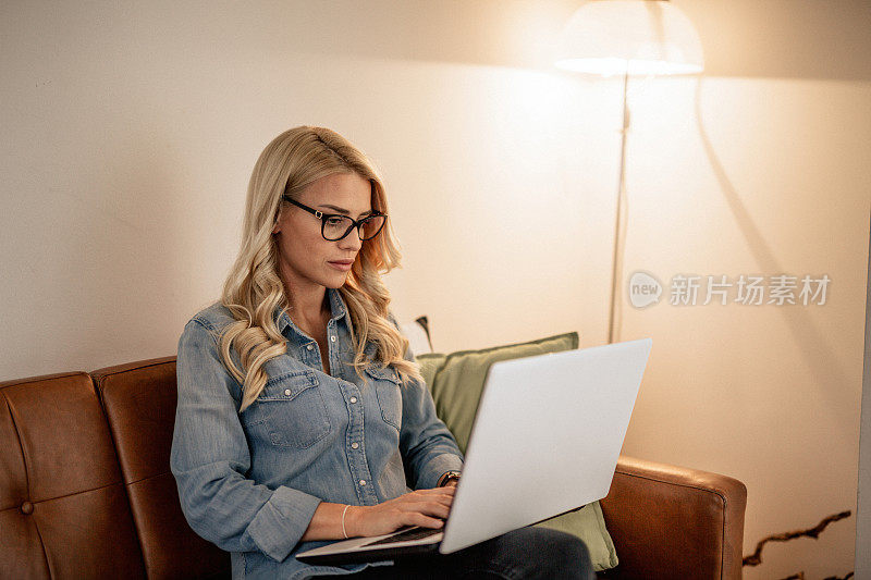 一个年轻女子在客厅里用笔记本电脑