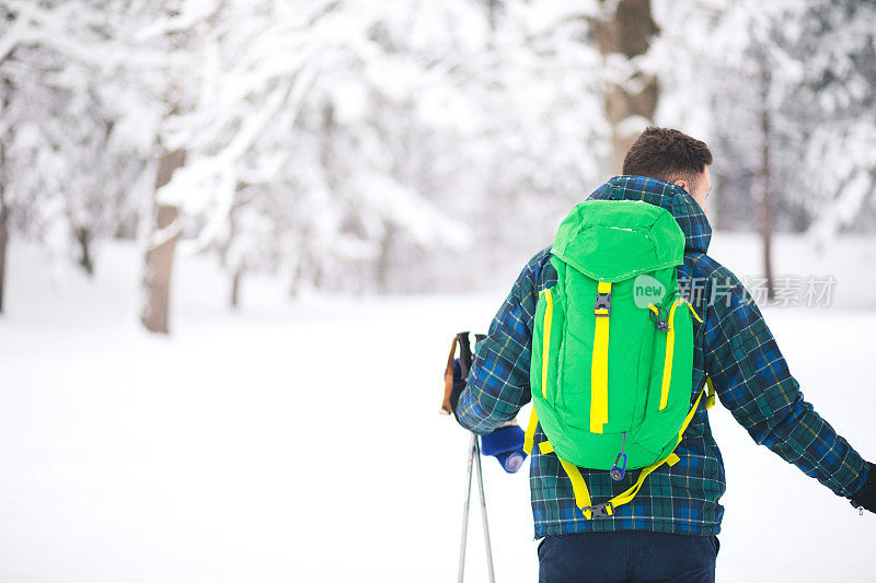 年轻人后视图独自行走雪山的旅行者。