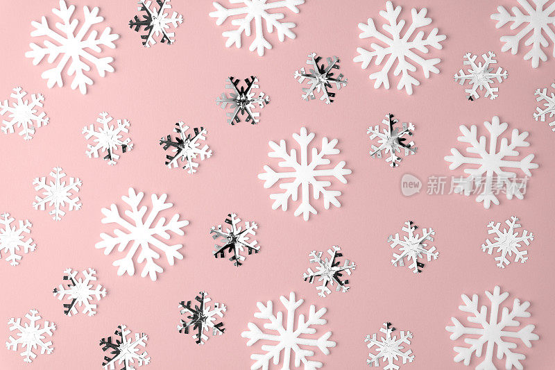 圣诞雪花图案平铺在粉红色柔和的背景上。前视图。最小的概念