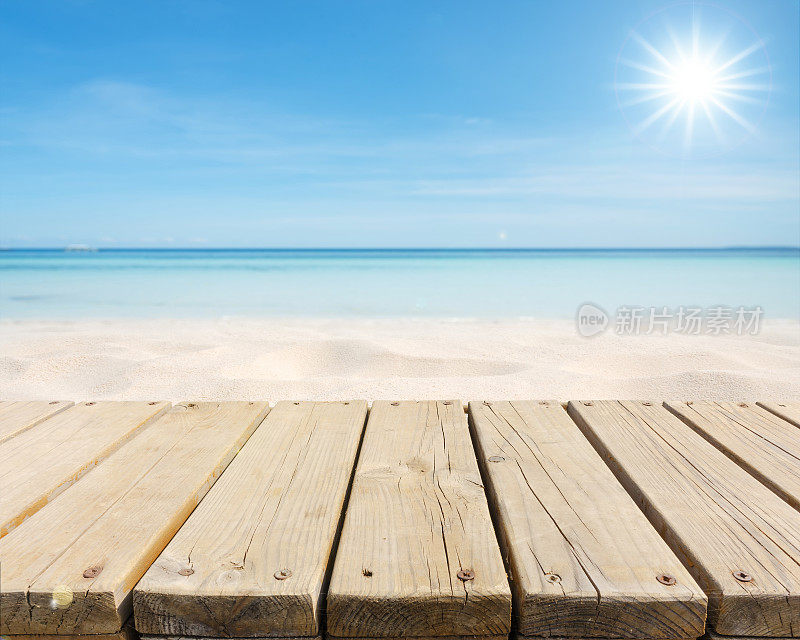 阳光下沙滩边空荡荡的木制平台