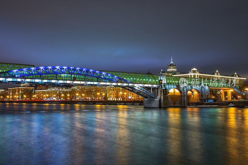 黄昏时分，城中灯火通明，河上架起一座大桥。