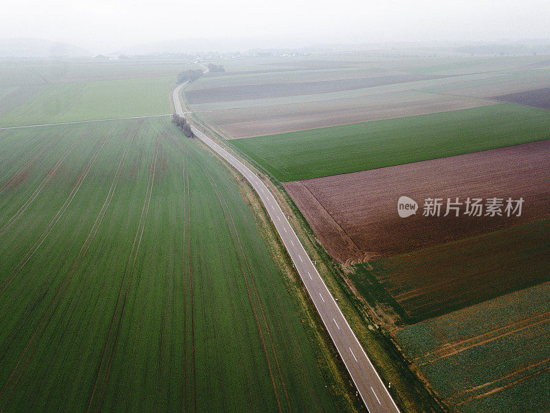 汽车鸟瞰图在雾蒙蒙的道路和丰富多彩的田野在德国