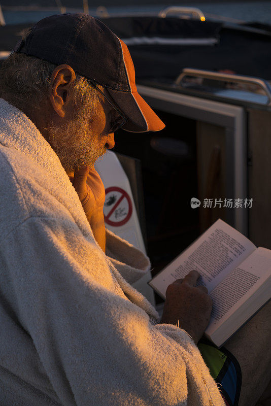 在克罗地亚亚得里亚海沿岸的晚上航行的资深男子与移动