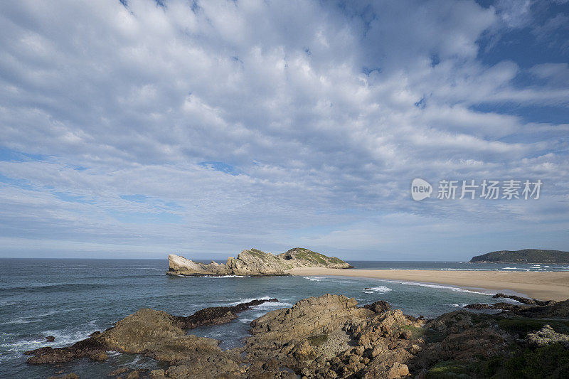 海浪拍打着岩石嶙峋的海岸线，拍打着天空