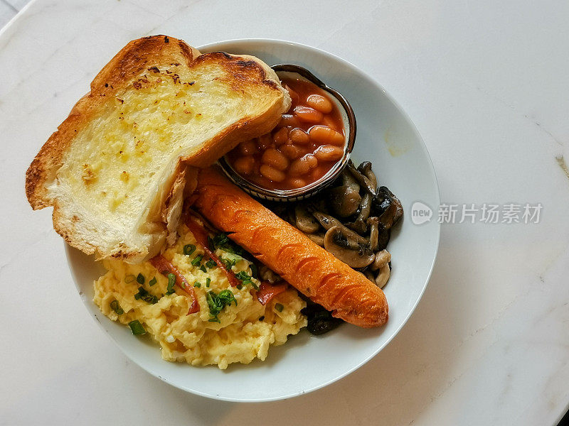 丰盛的早餐，混合了香肠、炒蛋、烤豆、蘑菇和吐司