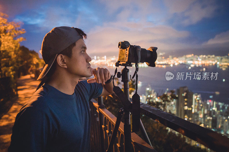 年轻的亚洲游客冒险拍摄香港的城市天际线在香港的famaus旅游胜地维多利亚峰