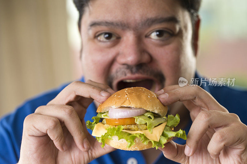 一个正在吃快餐汉堡的男人