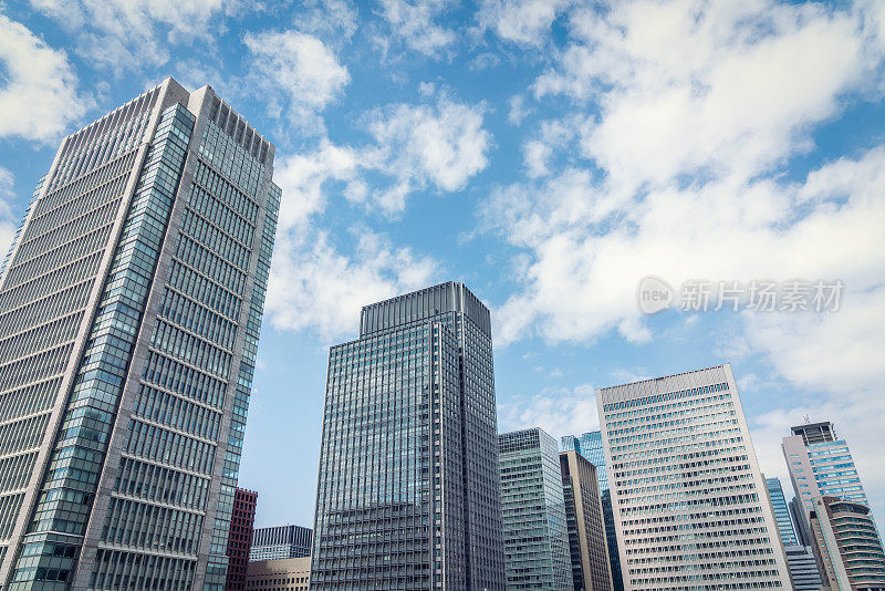 在日本东京，仰望蓝天白云的现代城市全景