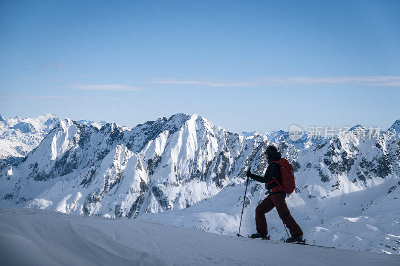 滑雪登山运动员攀登积雪的山脊线