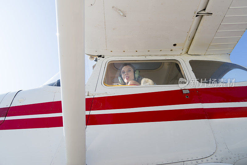 一架轻型飞机的女飞行员摆姿势拍照。