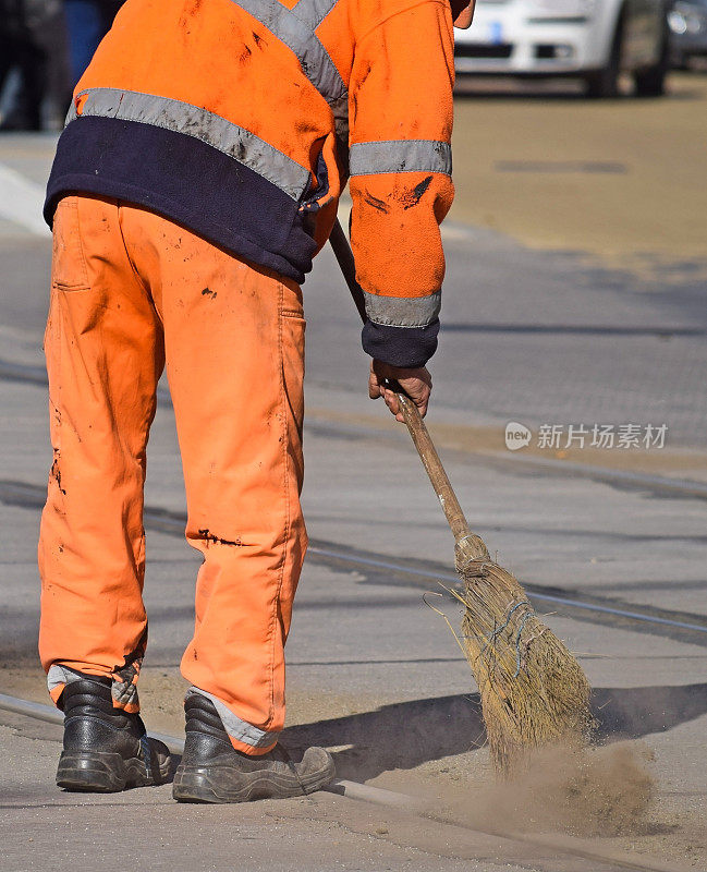 在城市里，街道清洁工用扫把工作