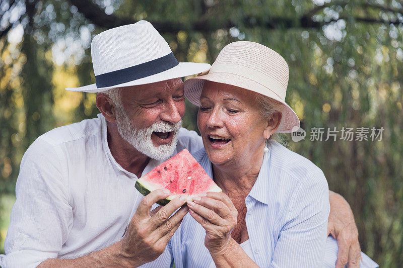 一对老夫妇在吃西瓜片的时候大笑