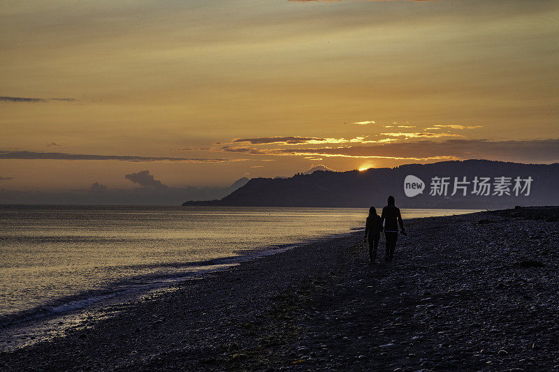 阿拉斯加半岛的日落，一对夫妇走在前面(认不出来)