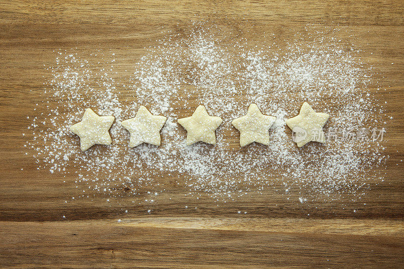 5星评价-糕点星和糖霜在木质表面上排成一排