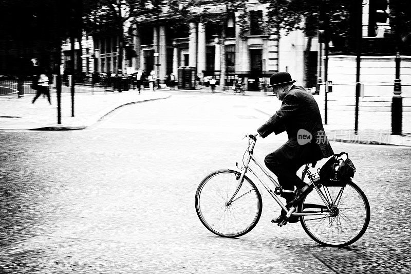 骑自行车的男人戴着圆顶礼帽
