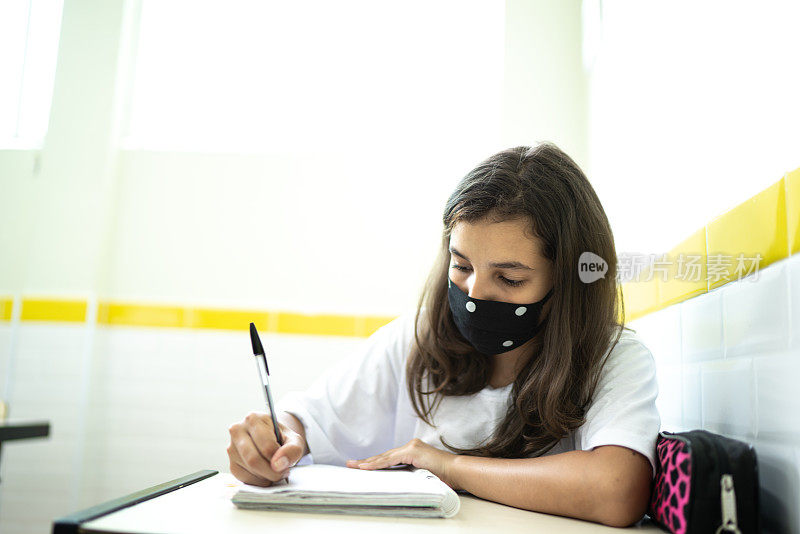 女学生戴着口罩在教室学习