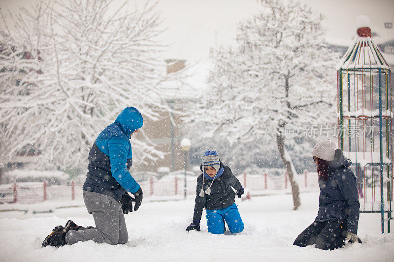 快乐的家庭在雪地上玩耍