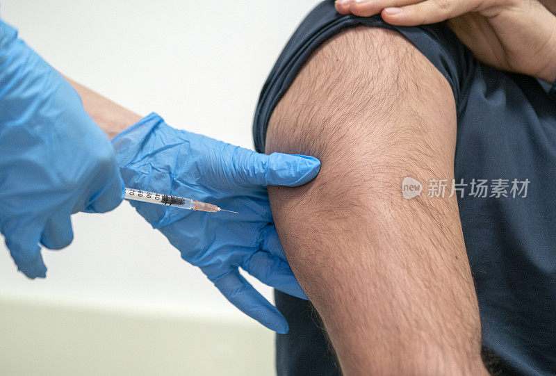 年轻男子接受冠状病毒疫苗库存照片