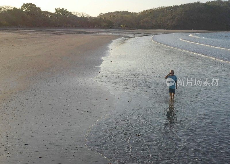 日出时，人们走在沙滩上