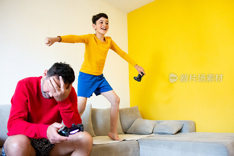 快乐的儿子和父亲在家里玩电子游戏