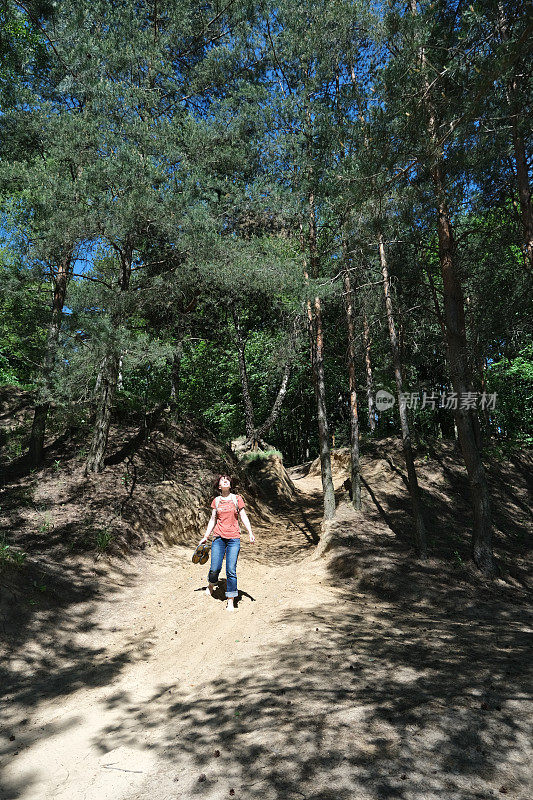 成熟的女人正在自然公园里走下山去