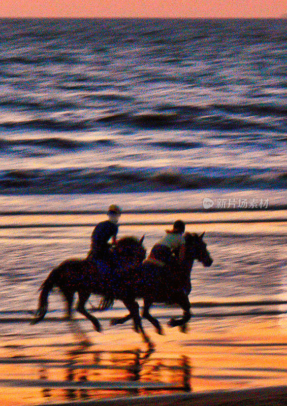 海滩上的人们在日落时骑马
