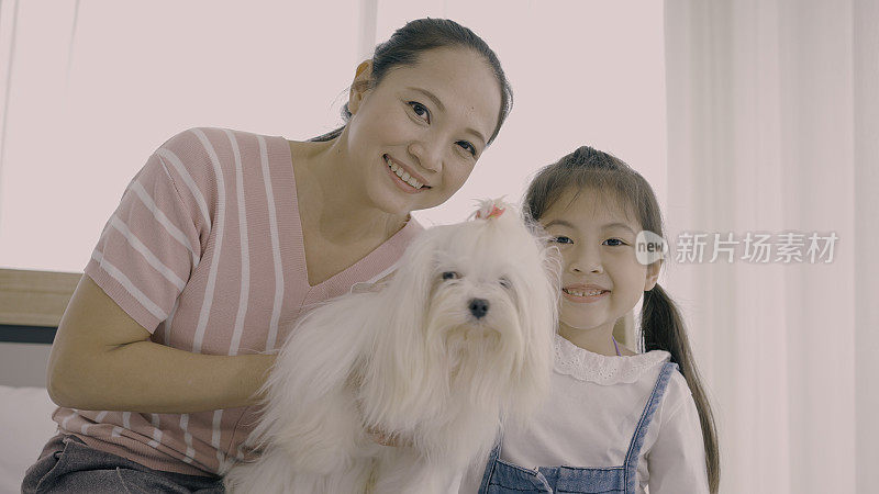 母亲和女儿与宠物狗的合影
