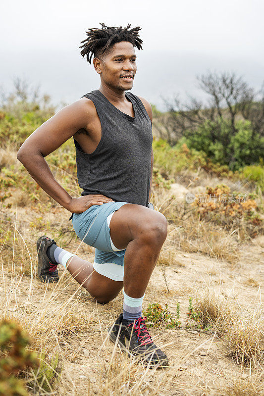 一个健康的年轻人在跑步前伸展一下双腿