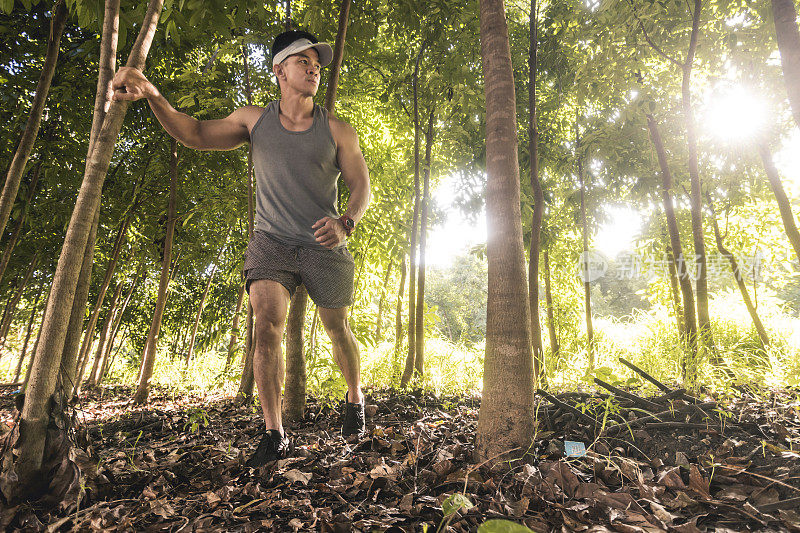 一个健康的亚洲人在一个顶级坦克徒步和探索森林。越野跑、冒险、健身理念。