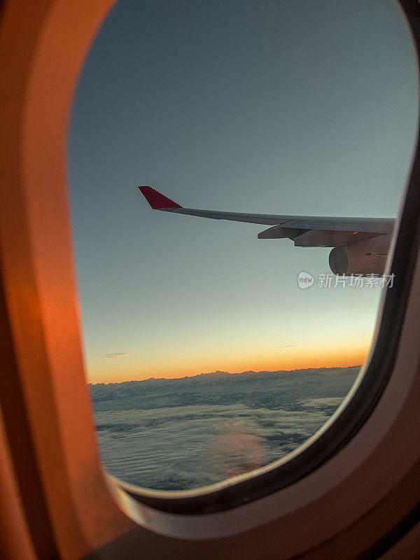 从飞机窗口往外看，美丽的日出在空中