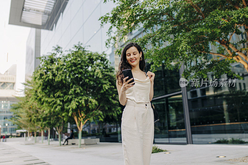 一个女人在街上用她的智能手机