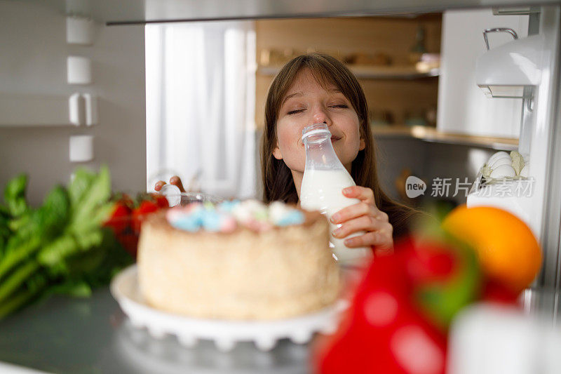 女孩用冰箱里的奶瓶闻牛奶