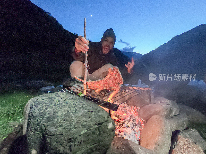 一名男子在篝火营里烤肉