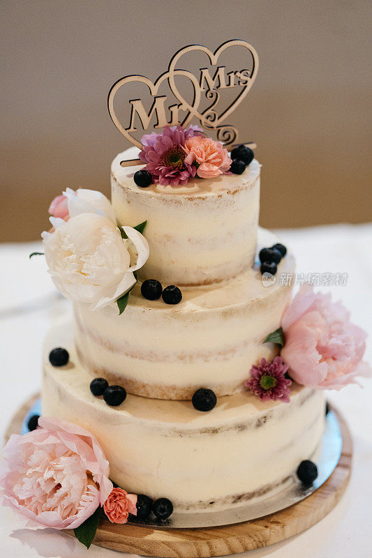 有玫瑰和蓝莓的半裸婚礼蛋糕