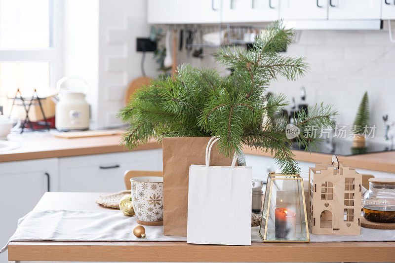 为圣诞节装饰的厨房餐桌上摆放着模拟的纸包。购物和礼物，礼物和即食食品都是为新年准备的