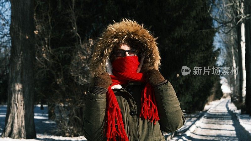 一名女游客在冬天的街道上被冻住了，她把脸藏在围巾里