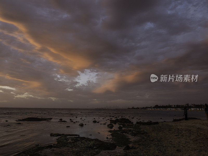 海滩和城市天际线上戏剧性的云层