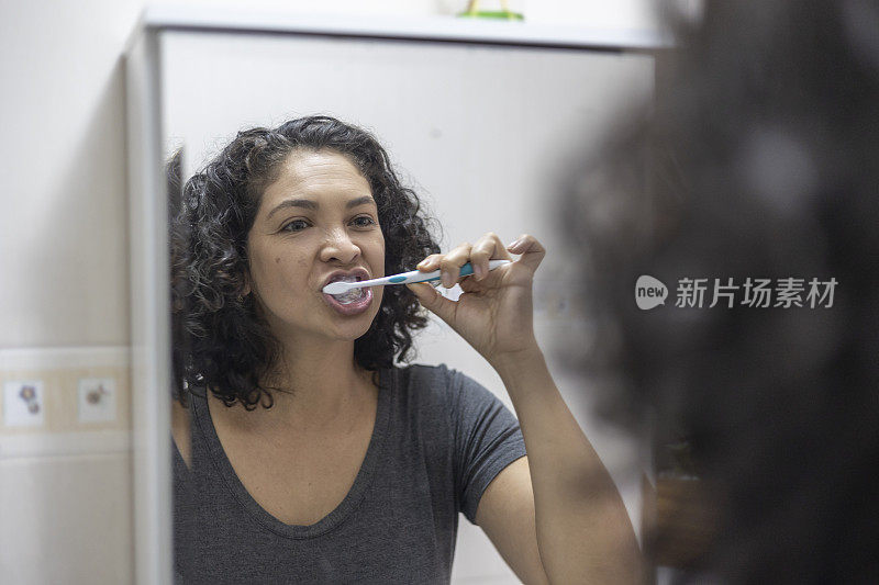 拉丁女人在浴室里愉快地刷牙