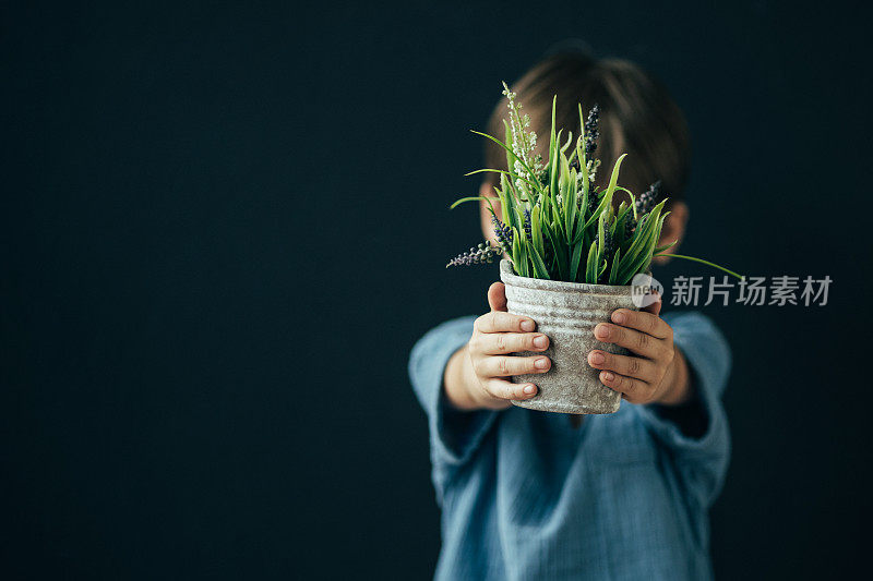 小男孩拿着花盆