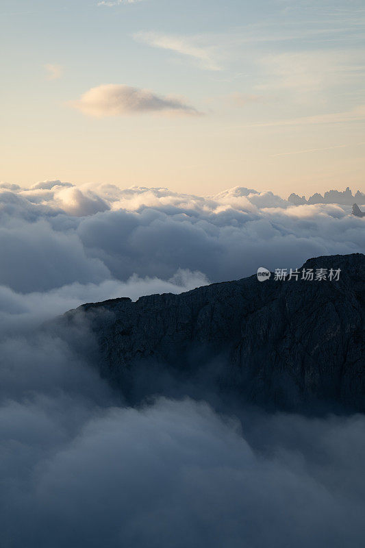 高耸的悬崖，山峰在云层之上的天空的宁静风景。特伦蒂诺山谷绝佳的旅游景点