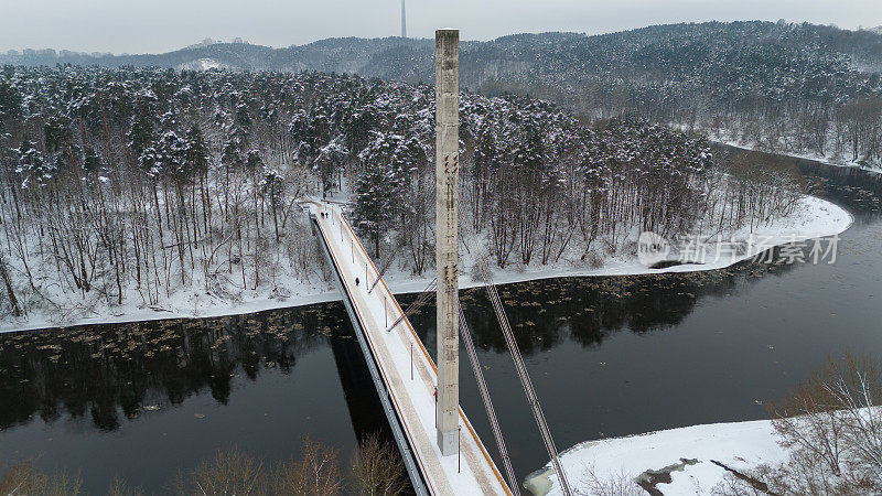 无人机拍摄的积雪覆盖的混凝土人行桥和冬日行人过街