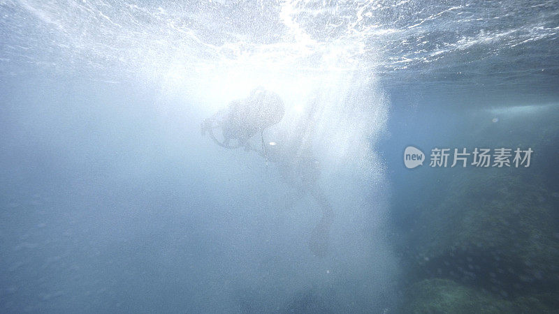 戴水肺的潜水员用水下摄影机探索大海